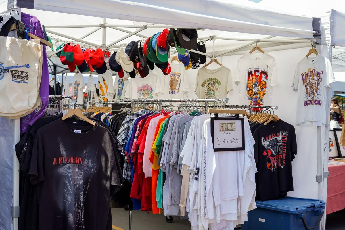 ราวแขวนเสื้อผ้าจัดเรียงสินค้าเป็นแถวที่แผงตลาดนัด